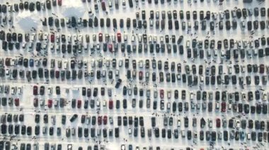 Satılık birçok arabanın hava manzarası ve kışın araba pazarında veya otoparkta yürüyen müşteriler..