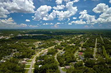 Aerial view of american small town in Florida with private homes between green palm trees and suburban streets in quiet residential area.
