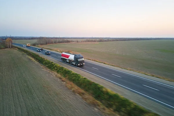 Aerial view of blurred fast moving fuel cargo truck driving on highway hauling goods. Delivery transportation and logistics concept.