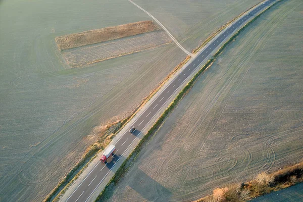 Aerial view of cargo truck driving on highway hauling goods. Delivery transportation and logistics concept.