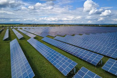 Temiz elektrik enerjisi üretmek için sıra sıra güneş fotovoltaik panelleri olan sürdürülebilir büyük elektrik santralinin havadan görünüşü. Sıfır emisyonlu yenilenebilir elektrik kavramı.