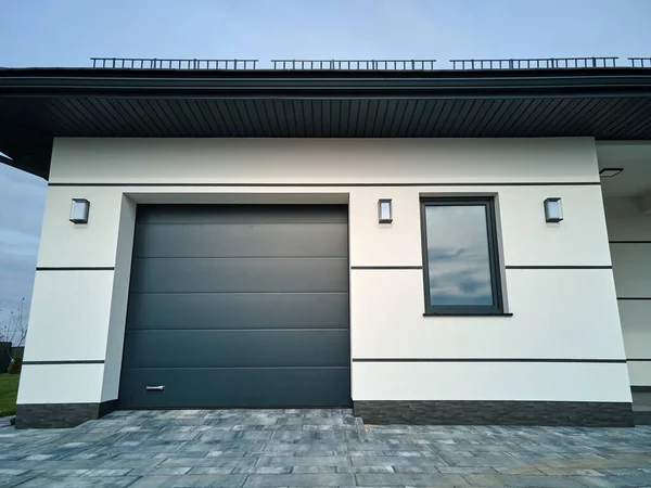 Automatic electric roll-up commercial garage gate or push-up door in modern private building ground floor.