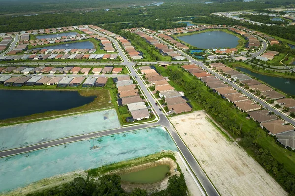 Real estate development with tightly located family houses under construction in Florida suburban area. Concept of growing american suburbs.