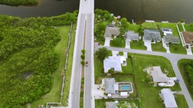 Küçük bir kasabada sokak trafiğinin hava görüntüsü. Florida 'da sakin yerleşim bölgesinde yeşil palmiye ağaçları arasında özel evleri olan Amerikan banliyö manzarası.