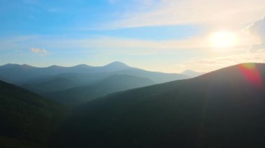 Gün batımında puslu tepeleri ve sisli vadisi olan güzel dağ panoramik manzarası.