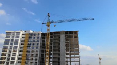 Tower cranes and frame structure of high residential apartment buildings at construction site. Real estate development.