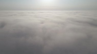 Dünya 'nın yüksek irtifasında, yağmur fırtınasından önce oluşan kabarık kümülüs bulutlarıyla kaplı uçak penceresinden hava görüntüsü.