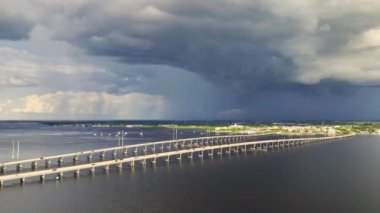 Aerial view of Barron Collier Bridge and Gilchrist Bridge in Florida with moving traffic. Transportation infrastructure in Charlotte County connecting Punta Gorda and Port Charlotte over Peace River.