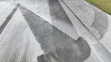 Aerial view of irrigation system watering farm field during dry season. Industrial sprinkler spraying water on farmland ground for crops growth during period of drought.
