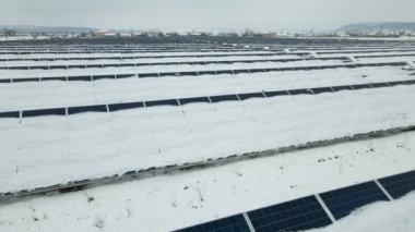 Kar, temiz elektrik enerjisi üretmek için birçok sıra güneş fotovoltaik paneliyle sürdürülebilir elektrik santralini kapladı. Kışın yenilenebilir elektriğin düşük etkisi.