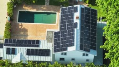 Banliyö bölgesinde temiz ekolojik elektrik enerjisi üretmek için çatısı güneş fotovoltaik panellerle kaplı pahalı bir Amerikan konutu. Özerk konut kavramı.