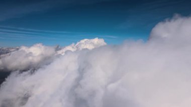 Dünya 'nın yüksek irtifasında, yağmur fırtınasından önce oluşan kabarık kümülüs bulutlarıyla kaplı uçak penceresinden hava görüntüsü.