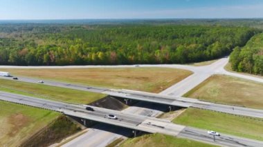 View from above of busy american highway with fast moving traffic between woods. Interstate transportation concept.