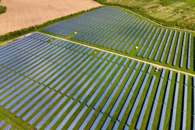 Temiz ekolojik elektrik enerjisi üretmek için birçok sıra güneş fotovoltaik paneli bulunan sürdürülebilir büyük elektrik santralinin havadan görünüşü. Sıfır emisyon kavramı ile yenilenebilir elektrik.