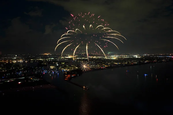 stock image Aerial view of bright fireworks exploding with colorful lights over sea shore on US Independence day holiday.