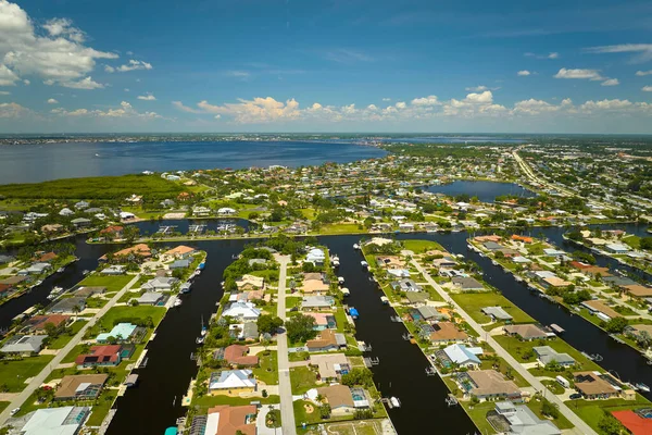 Aerial view of rural private houses in remote suburbs located on sea coast near Florida wildlife wetlands with green vegetation on gulf bay shore. Living close to nature in tropical region concept.