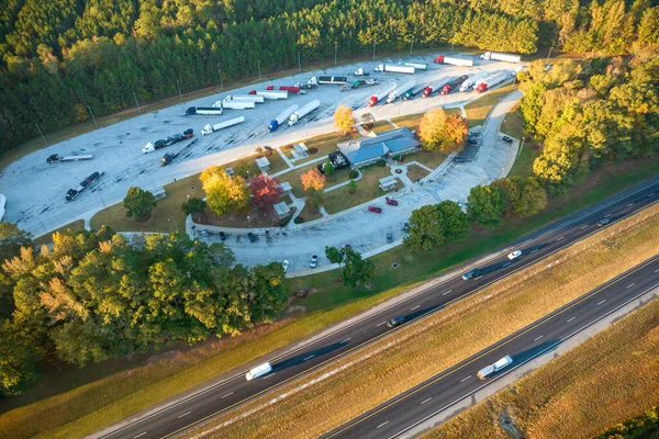 Large truck stop with resting area near busy american interstate freeway with fast driving cars and trucks. Recreational parking place during interstate travel.