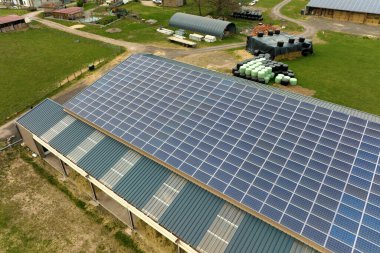Aerial view of farm building with photovoltaic solar panels mounted on rooftop for producing clean ecological electricity. Production of renewable energy concept.