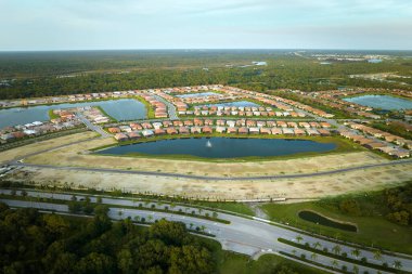 Florida 'nın kapalı banliyö bölgesinde inşaat halindeki aile evleri ile birlikte gayrimenkul gelişiminin havadan görüntüsü. Büyüyen Amerikan banliyöleri kavramı.