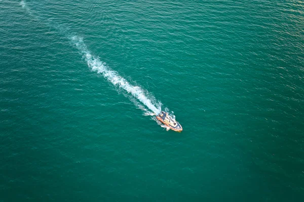 stock image Aerial view of white yacht swimming on sea waves with ripple surface. Motor boat in motion on ocean.