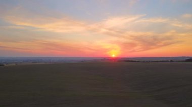 Parlak yaz akşamında olgun buğdayla ekili sarı tarım arazisinin havadan manzarası.