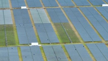 Temiz elektrik enerjisi üretmek için birçok sıra güneş fotovoltaik paneli bulunan sürdürülebilir büyük elektrik santralinin havadan görünüşü. Sıfır emisyon kavramı ile yenilenebilir elektrik.