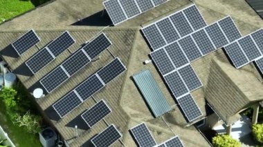 Temiz ekolojik elektrik enerjisi üretmek için mavi güneş fotovoltaik panelleri olan normal Amerikan ev çatısı. Emeklilik geliri için yenilenebilir elektriğe yatırım.