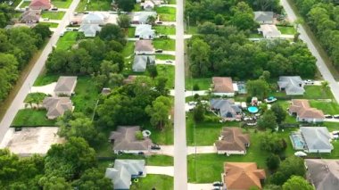 Florida 'nın sakin yerleşim bölgesinde yeşil palmiye ağaçları arasında özel evleri olan küçük bir Amerikan banliyö manzarası..