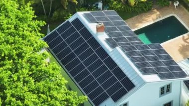 Banliyö bölgesinde temiz ekolojik elektrik enerjisi üretmek için çatısı güneş fotovoltaik panellerle kaplı pahalı bir Amerikan konutu. Özerk konut kavramı.