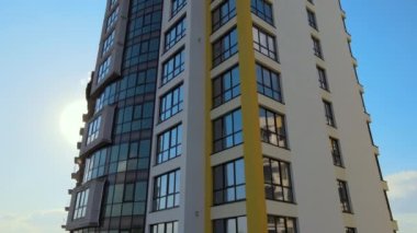 High residential apartment building with monolithic frame and glass windows under construction. Real estate development.