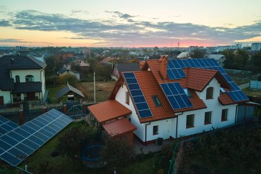 Temiz ekolojik elektrik enerjisi üretmek için sıralanmış mavi güneş fotovoltaik panelleri olan hava manzaralı çatı. Sıfır emisyon kavramı ile yenilenebilir elektrik.