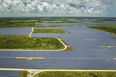 Temiz elektrik enerjisi üretmek için birçok sıra güneş fotovoltaik paneli bulunan sürdürülebilir büyük elektrik santralinin havadan görünüşü. Sıfır emisyon kavramı ile yenilenebilir elektrik.