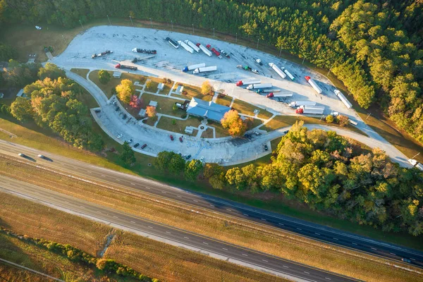 Large truck stop with resting area near busy american interstate freeway with fast driving cars and trucks. Recreational parking place during interstate travel.