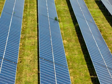 Temiz elektrik enerjisi üretmek için sıra sıra güneş fotovoltaik panelleri olan sürdürülebilir büyük elektrik santralinin havadan görünüşü. Sıfır emisyonlu yenilenebilir elektrik kavramı.