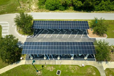 Aerial view of solar panels installed as shade roof over parking lot for parked cars for effective generation of clean electricity. Photovoltaic technology integrated in urban infrastructure.