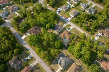 Aerial view of suburban landscape with private homes between green palm trees in Florida quiet residential area.