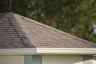 Closeup of house roof top covered with asphalt or bitumen shingles. Waterproofing of new building.