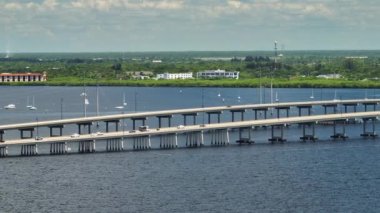 Aerial view of Barron Collier Bridge and Gilchrist Bridge in Florida with moving traffic. Transportation infrastructure in Charlotte County connecting Punta Gorda and Port Charlotte over Peace River.