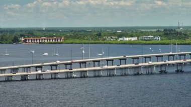 Aerial view of Barron Collier Bridge and Gilchrist Bridge in Florida with moving traffic. Transportation infrastructure in Charlotte County connecting Punta Gorda and Port Charlotte over Peace River.