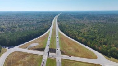 Aerial view of freeway overpass junction with fast moving traffic cars and trucks in american rural area. Interstate transportation infrastructure in USA.