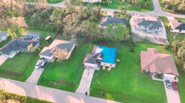 Ian Kasırgası, asfalt kiremitleri değişene kadar yağmur suyuna karşı koruyucu plastik muşambayla kaplı evin çatısına zarar verdi. Doğal afetten sonra.