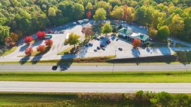 Top view of large rest area near busy multilane american freeway with fast moving cars and trucks. Recreational resting place during interstate traveling.