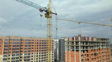 Tower lifting cranes at high residential apartment buildings construction site. Real estate development.