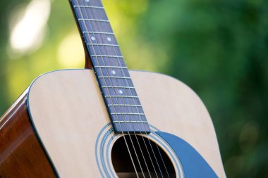 Acoustic guitar outdoors on greenery background. Concept of calm music.