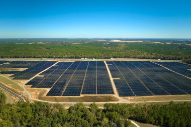 Temiz elektrik enerjisi üretmek için birçok sıra güneş fotovoltaik paneli bulunan sürdürülebilir büyük elektrik santralinin havadan görünüşü. Sıfır emisyon kavramı ile yenilenebilir elektrik.