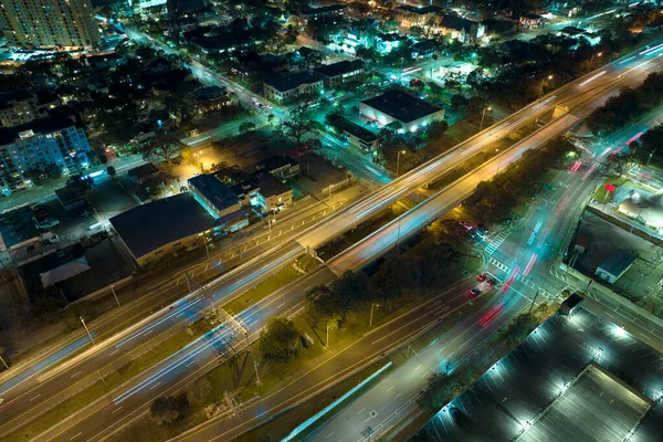 Aerial view of american freeway intersection at night with fast driving cars and trucks in Tampa, Florida. View from above of USA transportation infrastructure.