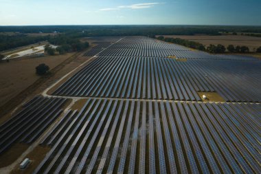 Temiz elektrik enerjisi üretmek için sıra sıra güneş fotovoltaik panelleri olan sürdürülebilir büyük elektrik santralinin havadan görünüşü. Sıfır emisyonlu yenilenebilir elektrik kavramı.