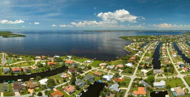 Körfez kıyısında, deniz kıyısında yeşil bitki örtüsü olan sulak alanlara yakın özel evleri olan yerleşim yerlerinin havadan görüntüsü. Doğa kavramına yakın yaşamak.