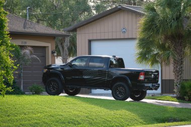 Car parked in front of wide garage double door on concrete driveway of new modern american house.