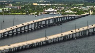 Aerial view of Barron Collier Bridge and Gilchrist Bridge in Florida with moving traffic. Transportation infrastructure in Charlotte County connecting Punta Gorda and Port Charlotte over Peace River.